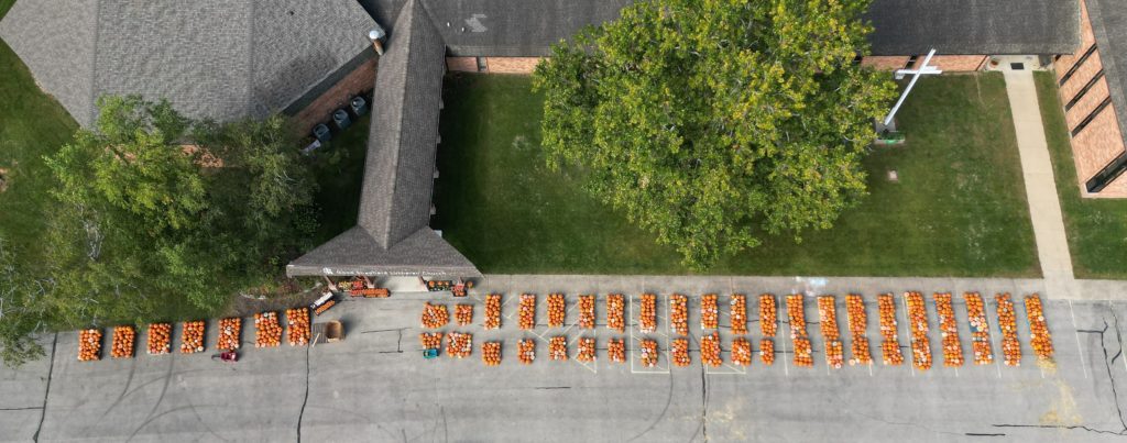 Aerial shot of pumpkins in the parking lot at church.